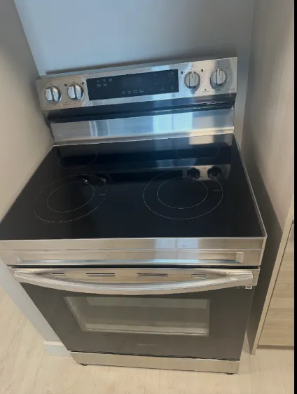 Stainless range and glass cooktop polished after move-out cleaning, photographed by the client